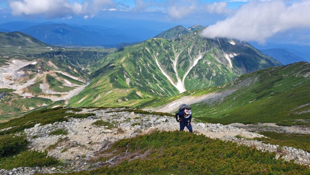 A hiker climbs up the side of the Tateyama mountain chain in July.